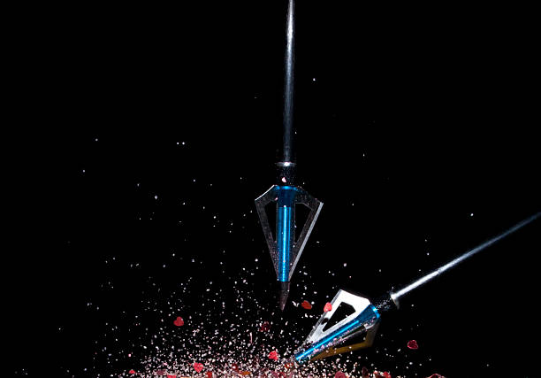 Two arrows intersecting amidst the shattered pieces of a heart